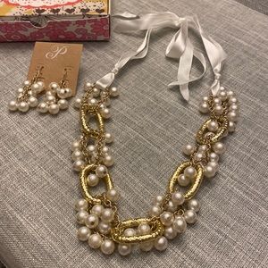 Gold and pearl necklace on a cream ribbon tie